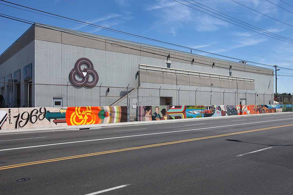 'TRI IT' - a mural on the fence outside the TriMet Maintenance Facility incorperates bold colors and historical imagry