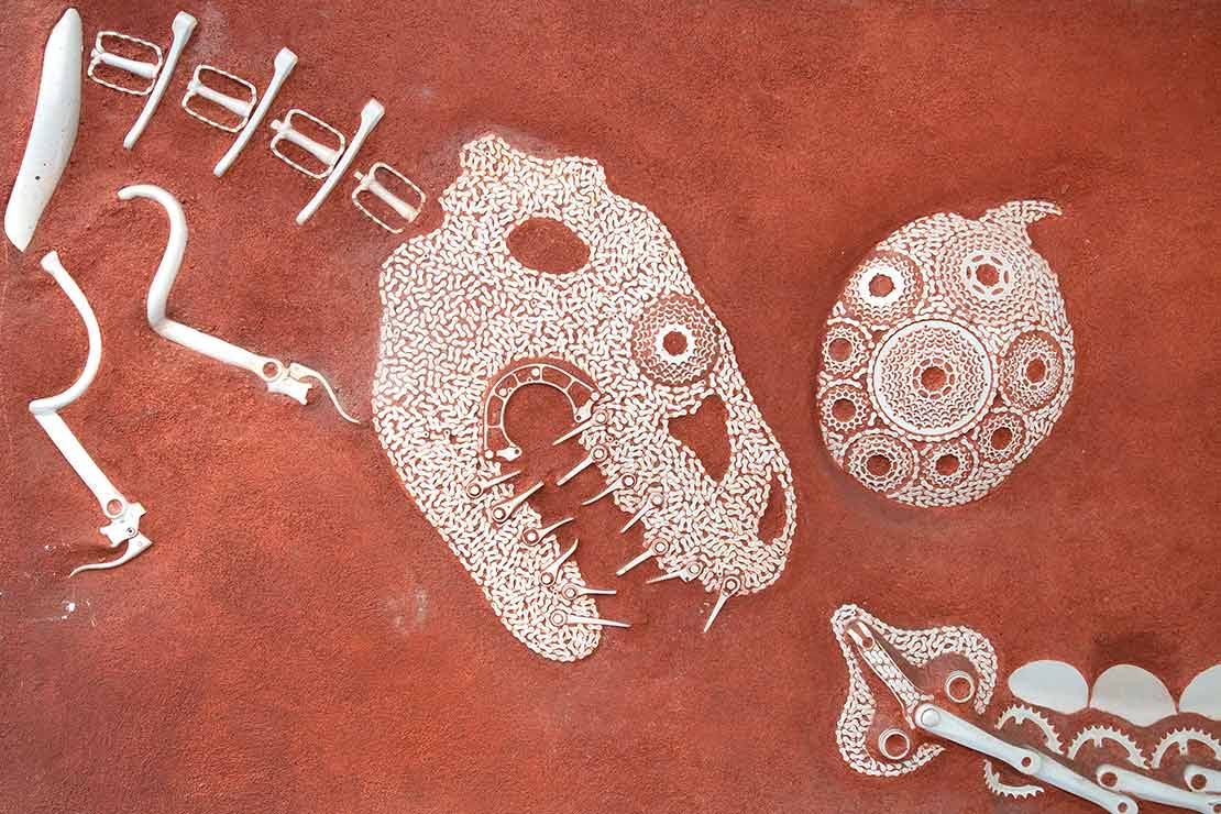 'Velosaurus' - found art bicycle parts in the shape of dinosaur bones inset into red concrete
