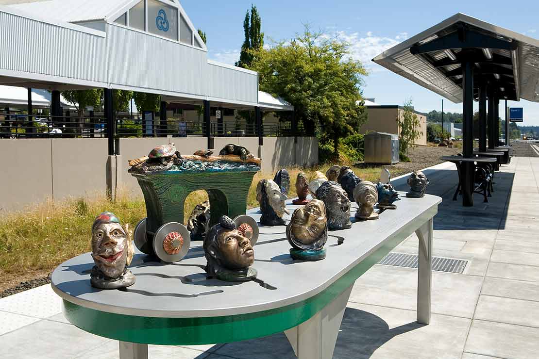 The Tigard Interactivator sculptural heads with masks on a metal table