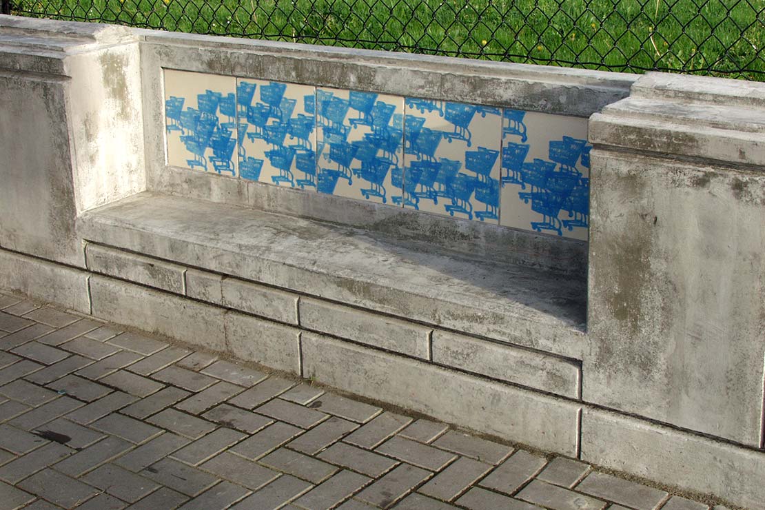 Seating wall - a built-in concrete bench with blue shopping cart stencils